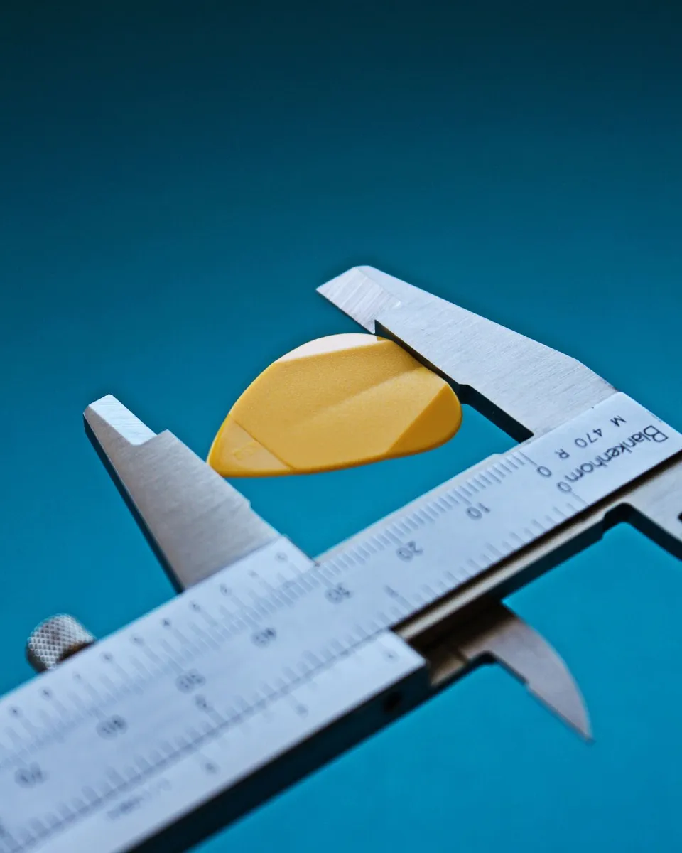 Technician measuring plastic part dimensions in QA lab - Pexels