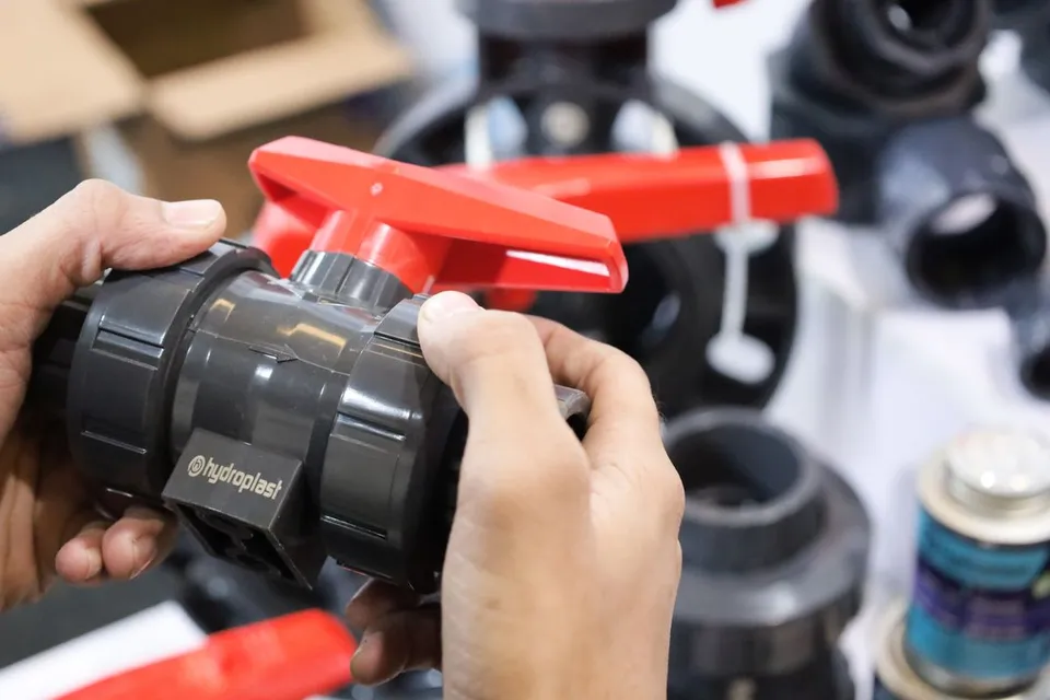 Hands inspecting an industrial valve at an exhibition - Pexels