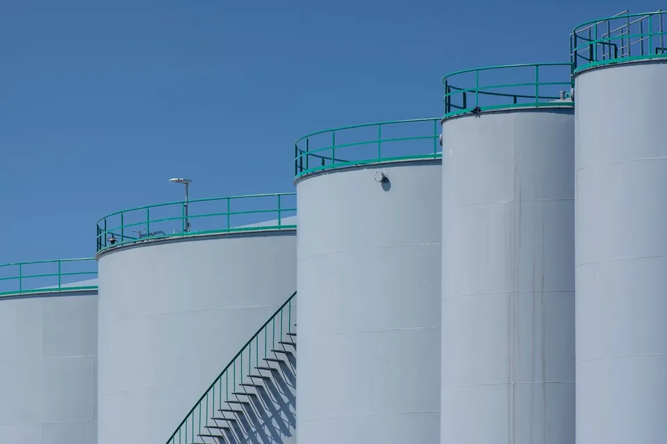 伫立在晴朗蓝天下的巨大圆柱形储罐 - Pexels